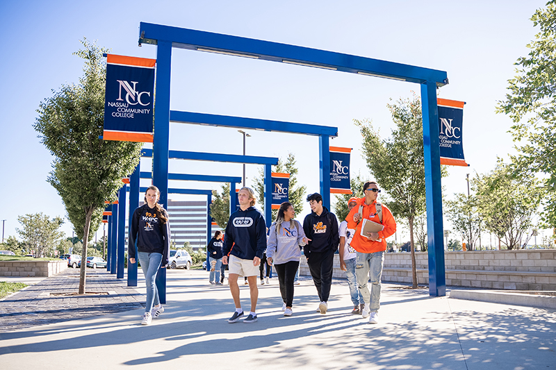 Student walking under the main gates