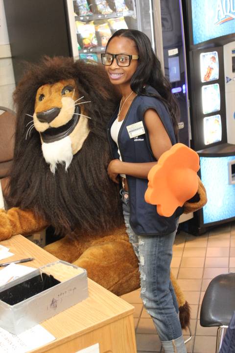 Student posed with Nassau Mascot Leo the lion